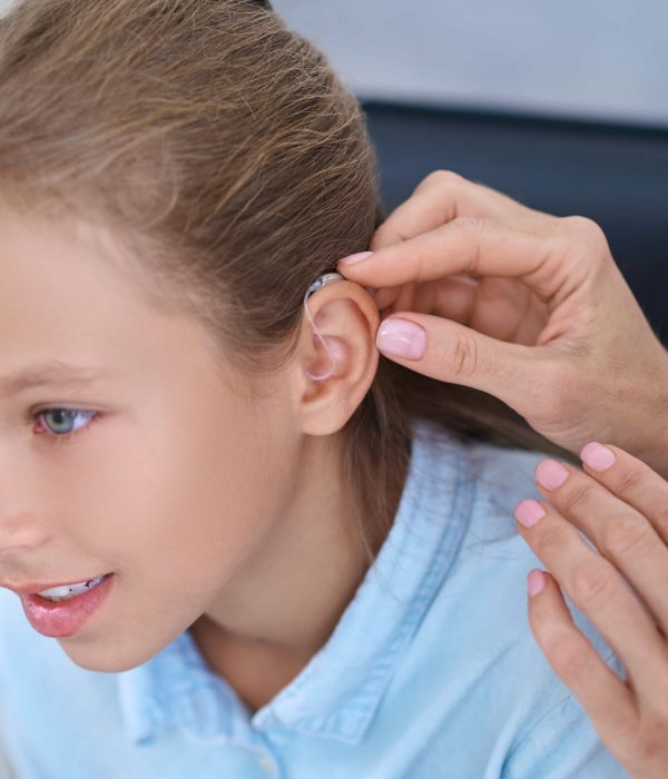 female-patient-having-hearing-device-attached-her-ear female-patient-having-hearing-device-attached-her-ear